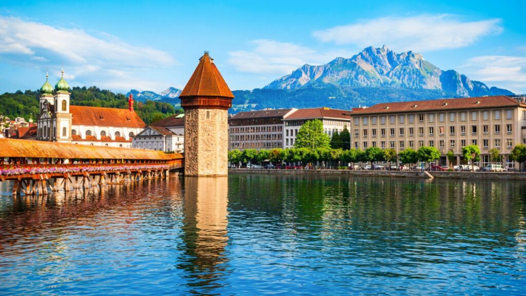 Historic Chapel Bridge and Water Tower in Lucerne Switzerland with lake views.